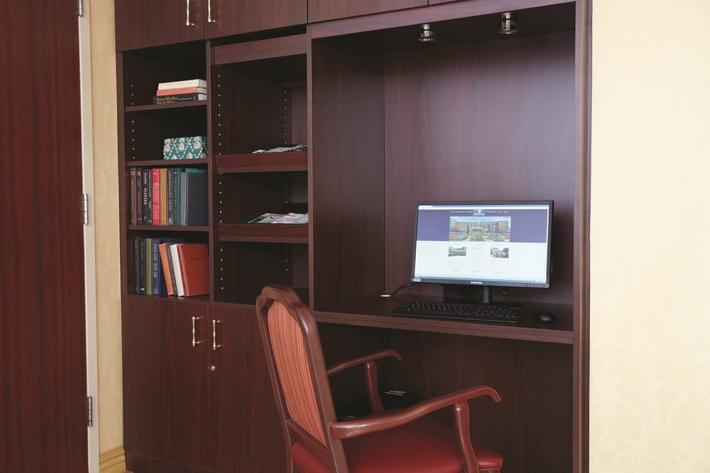 A compact home office setup with a computer desk, bookshelf, and chair.