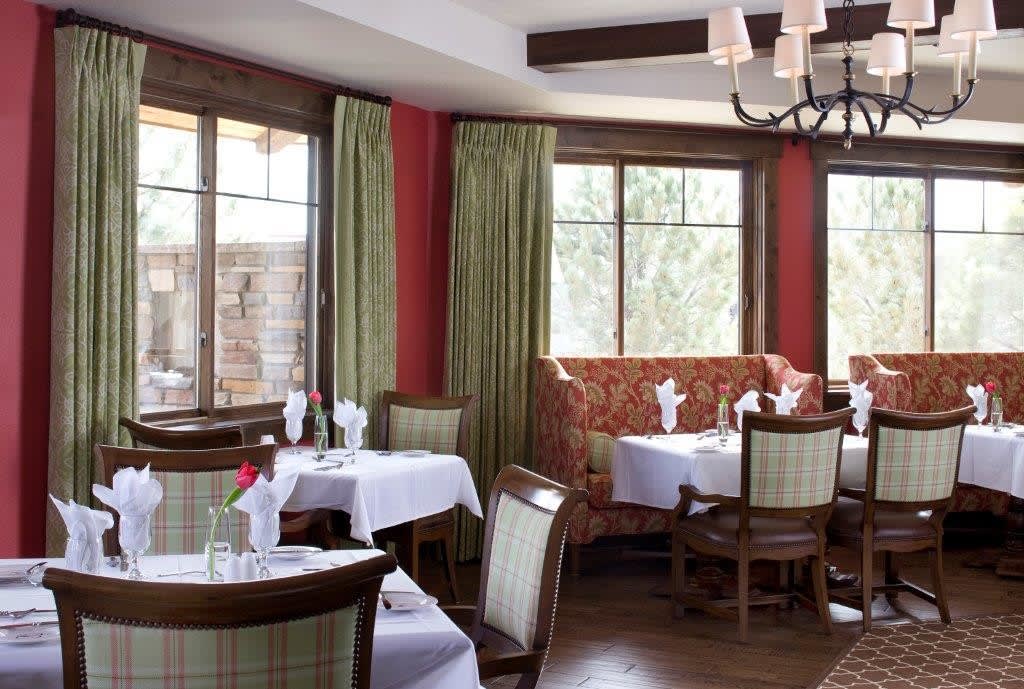 A cozy restaurant dining area with elegantly set tables and comfortable seating.