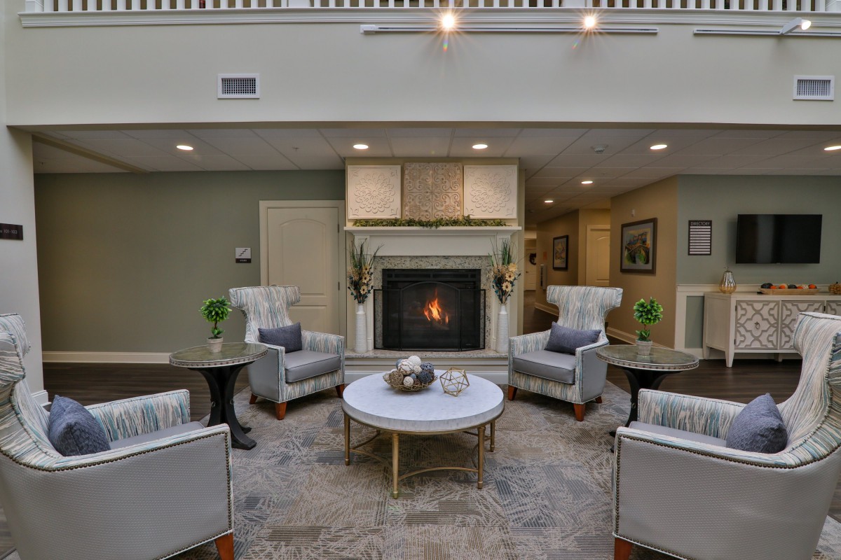 A cozy living room with a fireplace surrounded by comfortable armchairs and modern decor.