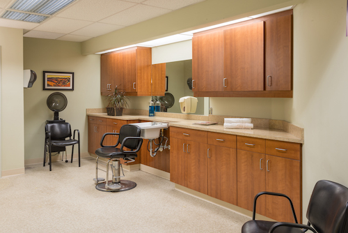 A well-organized hair salon interior featuring stylish chairs and cabinetry.