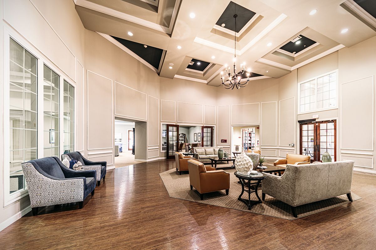 A luxurious and spacious living room with elegant seating arrangements and a sophisticated chandelier.