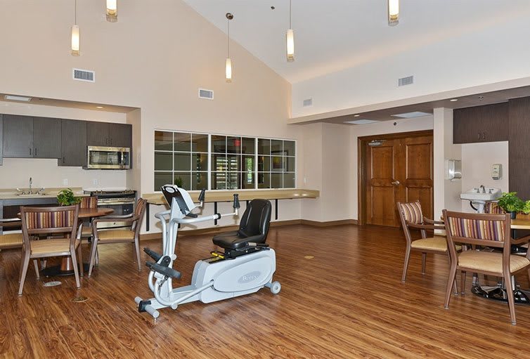 A spacious indoor room with an exercise bike and wooden flooring.