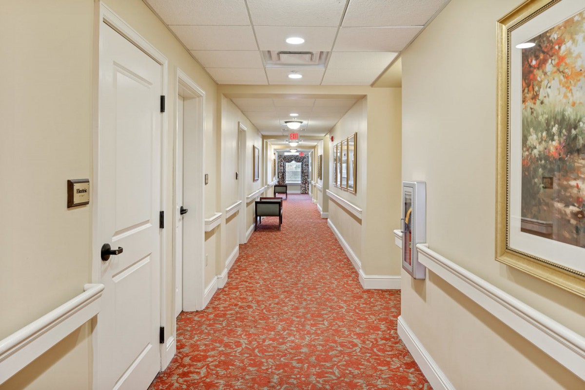A well-lit hallway with multiple doors and a patterned carpet.