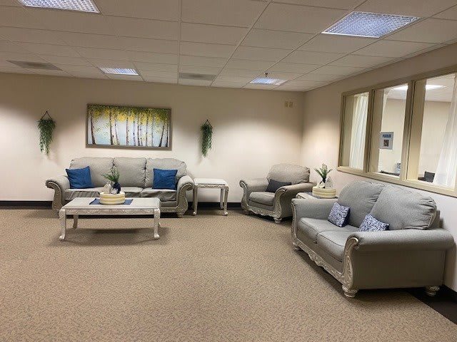 A comfortable waiting room with sofas and a coffee table.