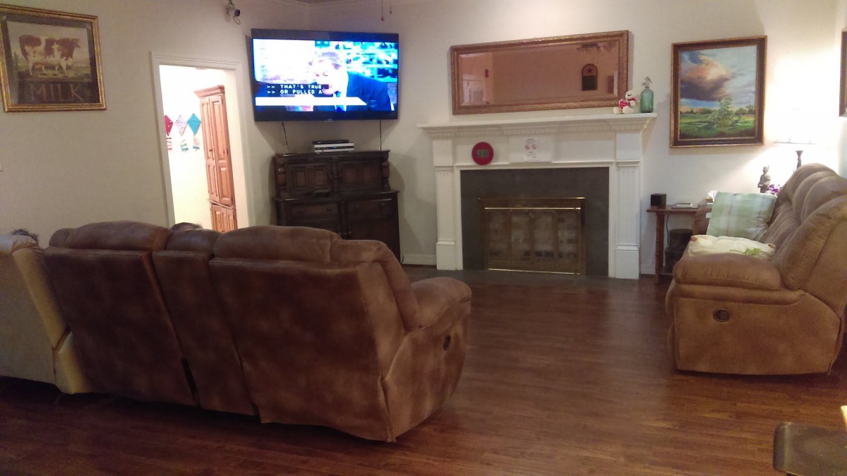 Cozy living room with a wall-mounted TV and a comfortable sofa.