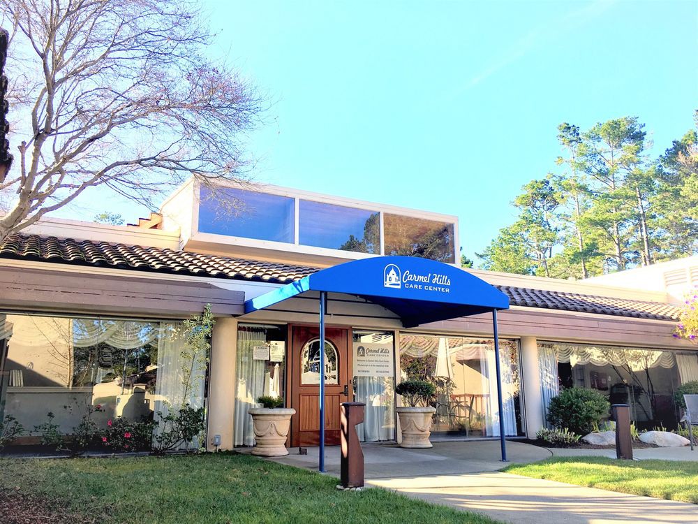 An entrance to a building with a blue awning and glass doors.