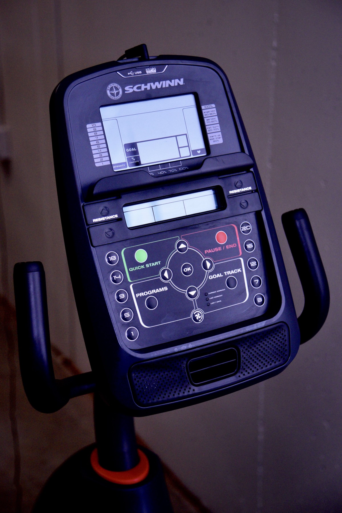 A close-up view of an exercise bike control panel with various settings and display screens.