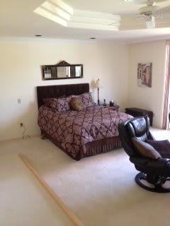 A cozy bedroom with a bed and recliner chair.