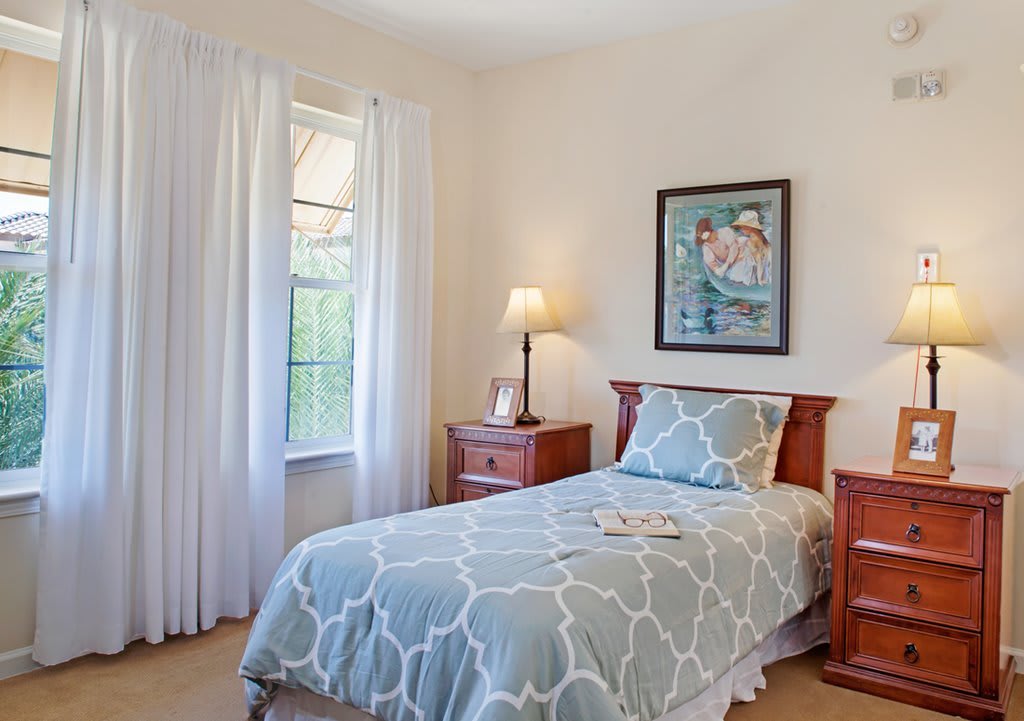 A cozy bedroom with a single bed and decorative elements.