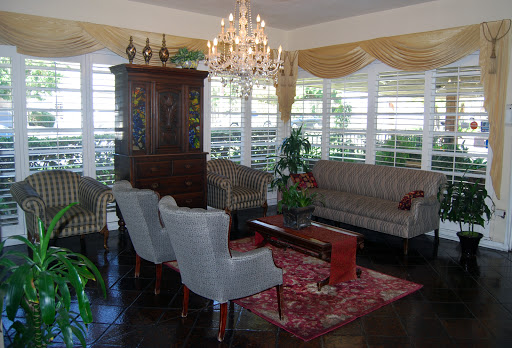 A stylish living room featuring elegant furniture, a chandelier, and decorative elements.