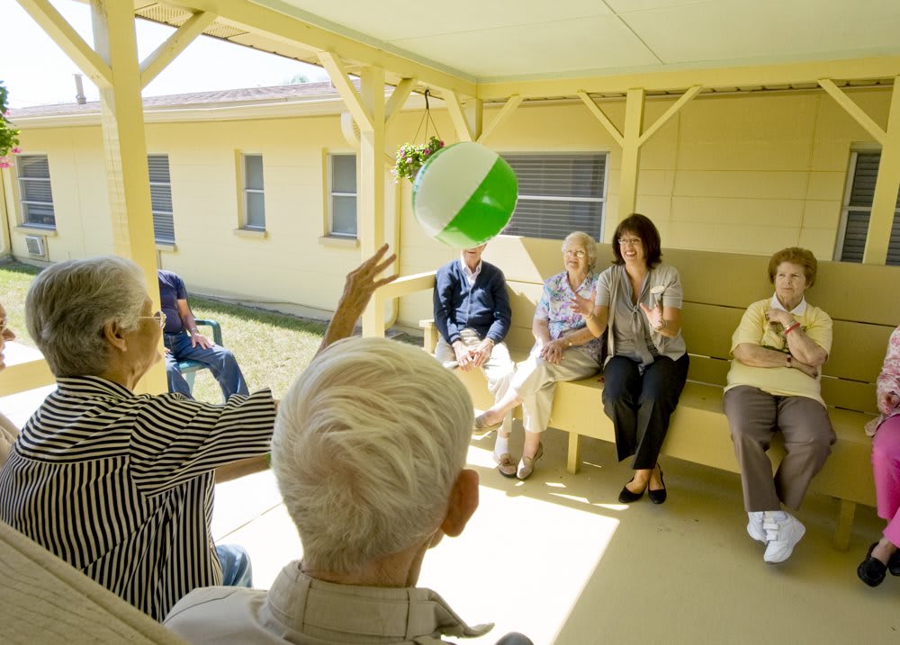 A group of elderly people engaging in a ball toss activity outdoors.
