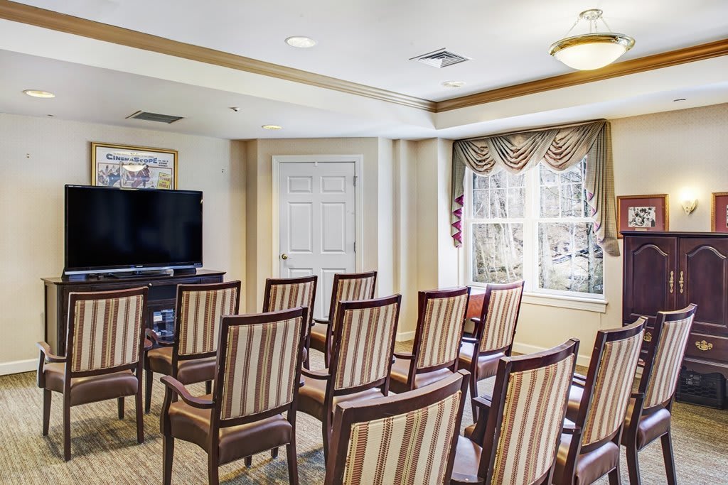A small conference room with arranged chairs facing a television.