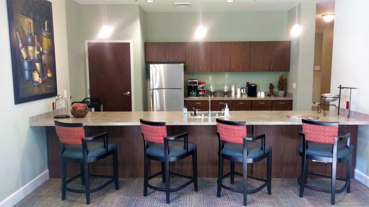 Modern kitchen with bar stools and a spacious countertop.