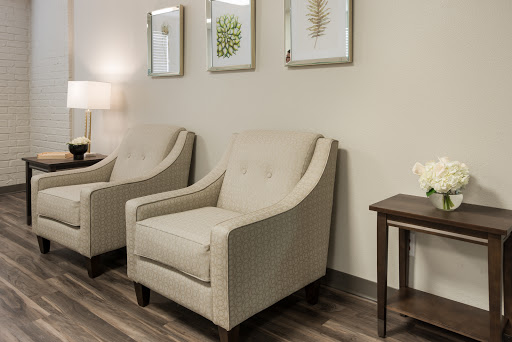 A cozy living space featuring two elegant chairs, a side table, and stylish wall art.