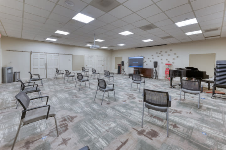 An empty conference room with chairs arranged in a socially distanced manner.