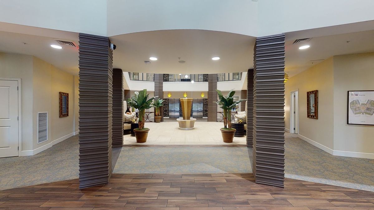 A spacious and modern lobby area with a central fountain and decorative plants.