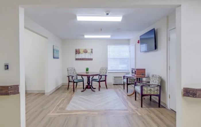 A cozy and well-lit small meeting area with tables and chairs.