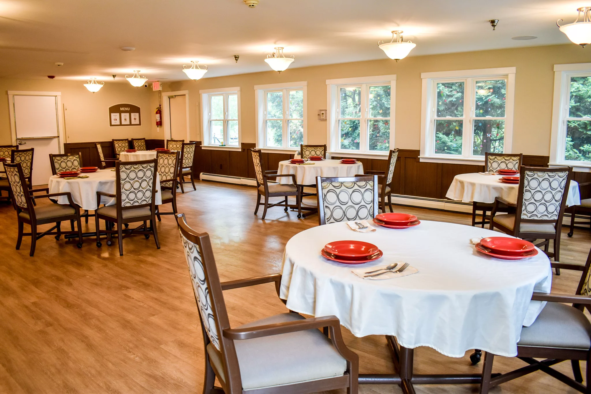 A spacious dining room with elegantly set tables and ample natural light.