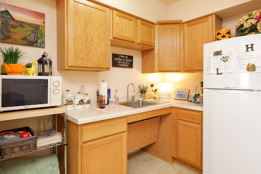 A cozy kitchen featuring wooden cabinets, a functional countertop, and essential appliances.