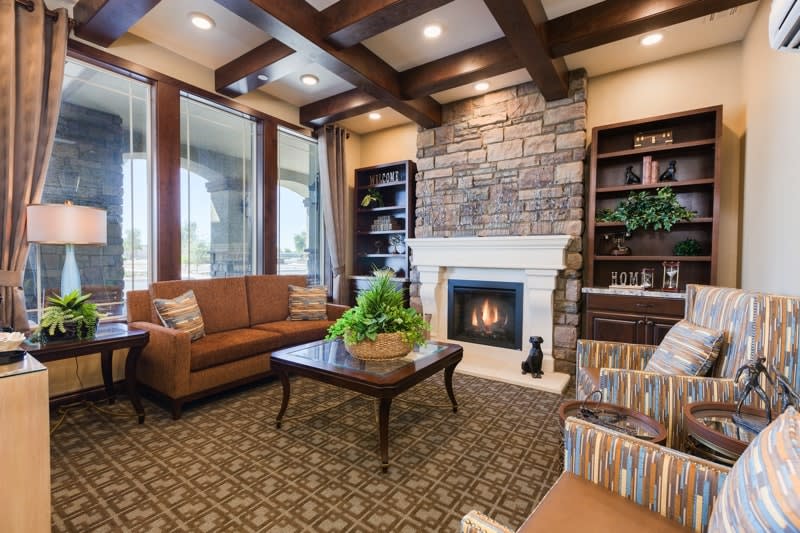 A cozy living room featuring a stone fireplace, comfortable seating, and elegant decor.