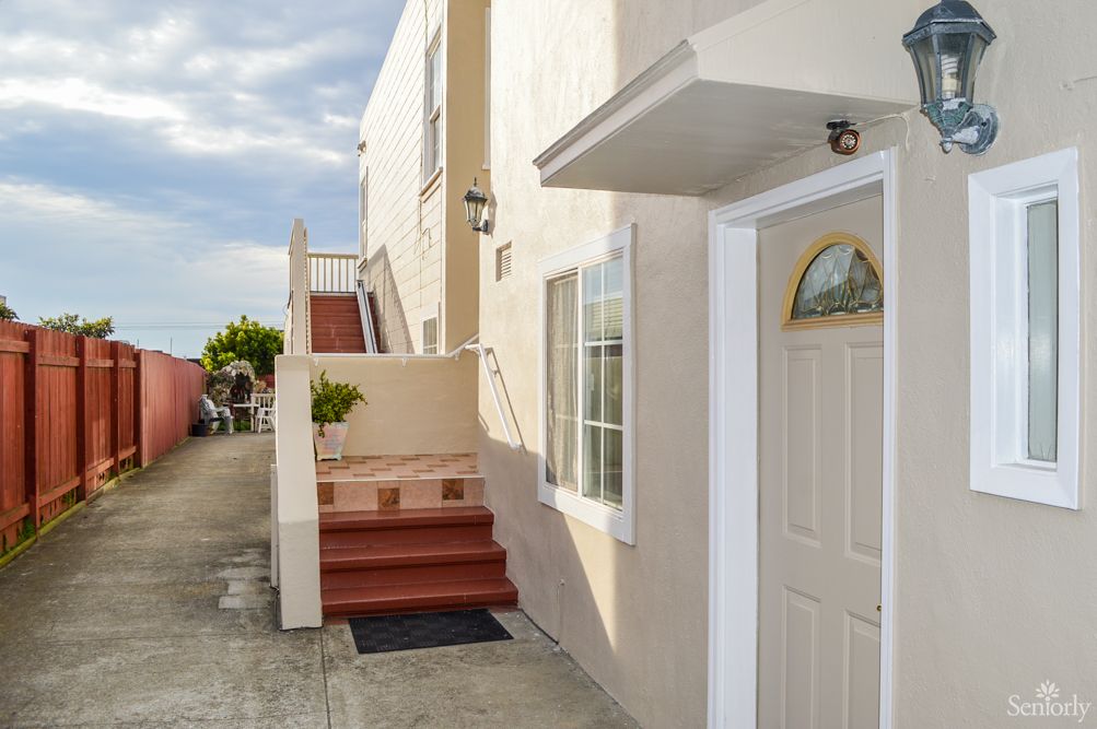 A view of a house entrance with stairs leading up to a higher level.