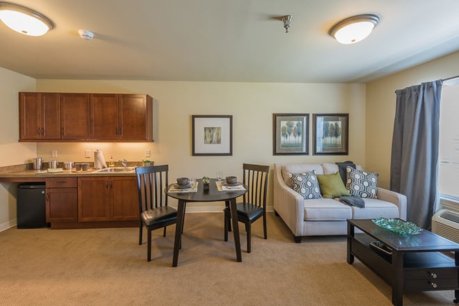 A cozy apartment living room with a small dining area and comfortable furniture.