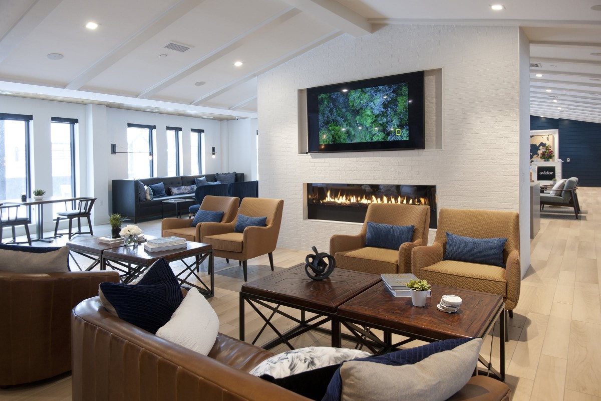 A modern living room featuring comfortable seating, a sleek fireplace, and a large television.