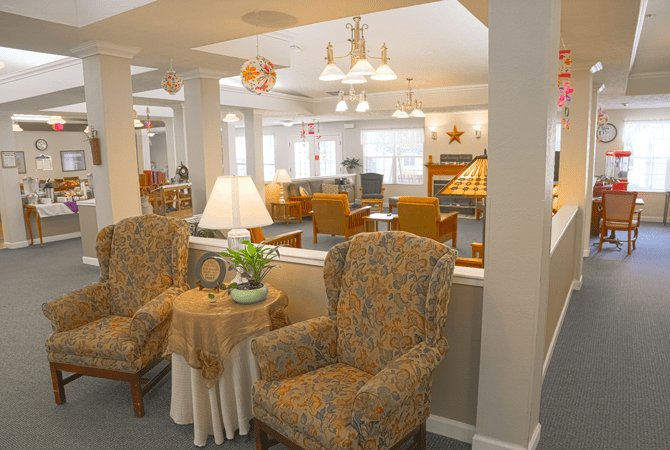 A cozy living room with upholstered chairs and elegant lighting.