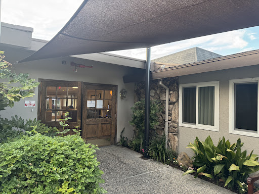 A welcoming entrance featuring a shaded walkway and lush greenery.