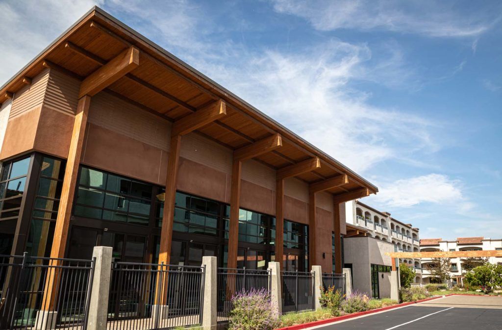 A modern commercial building with large windows and wooden architectural elements.