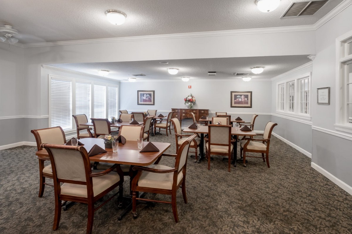 A spacious dining room with neatly arranged tables and chairs, featuring elegant decor.
