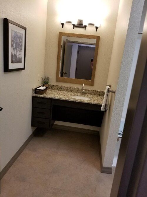 A well-organized bathroom with a wall-mounted mirror and sink.