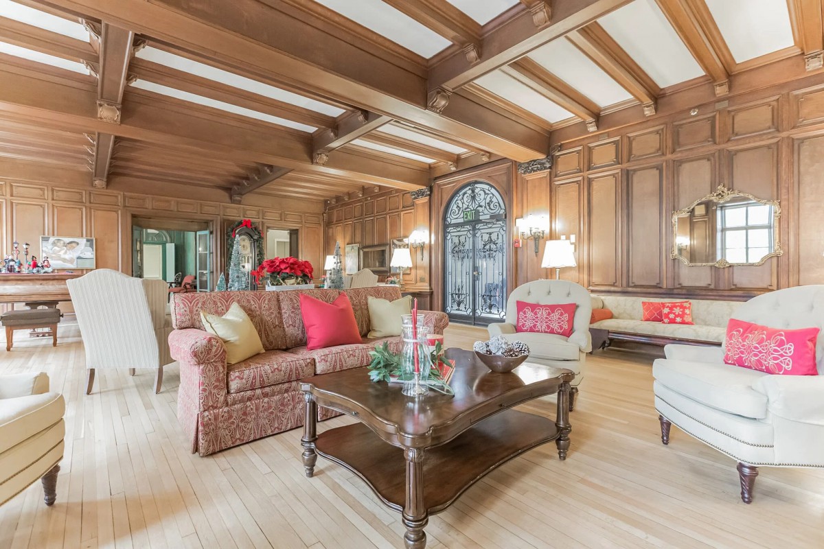 A cozy living room with traditional wood paneling and elegant furnishings.