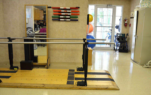 A physical therapy studio equipped with a barre and various exercise tools for rehabilitation and fitness.
