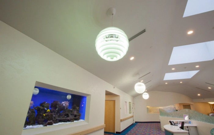A modern corridor with unique lighting fixtures and an aquarium display.