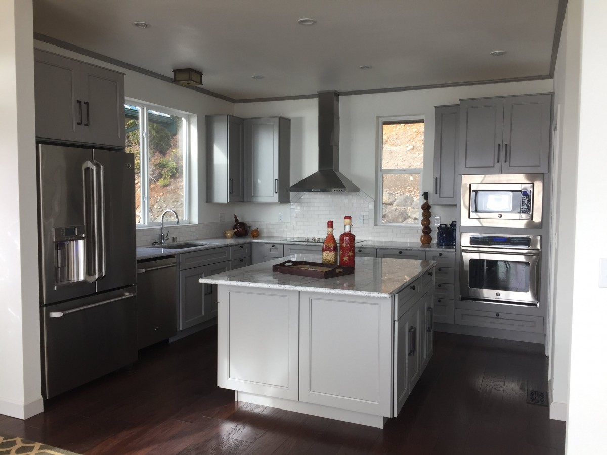 A modern kitchen with a central island and stainless steel appliances.