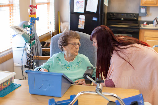 A caregiver engages in a warm conversation with an elderly resident, fostering connection and support.