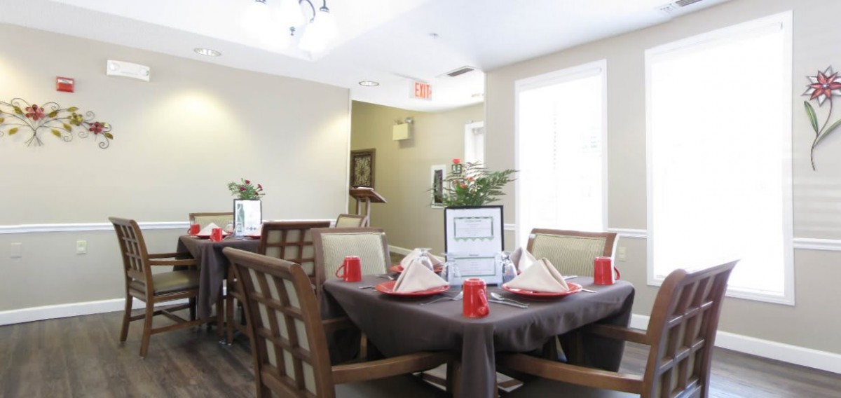 A cozy dining area with neatly set tables and comfortable chairs.