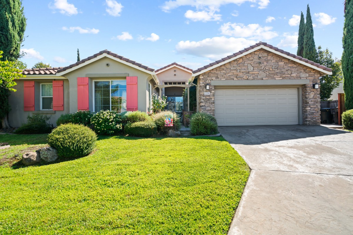 A single-story suburban home with a well-maintained front yard and a double garage.