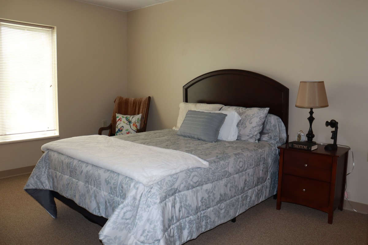 A cozy bedroom with a neatly made bed and bedside table.