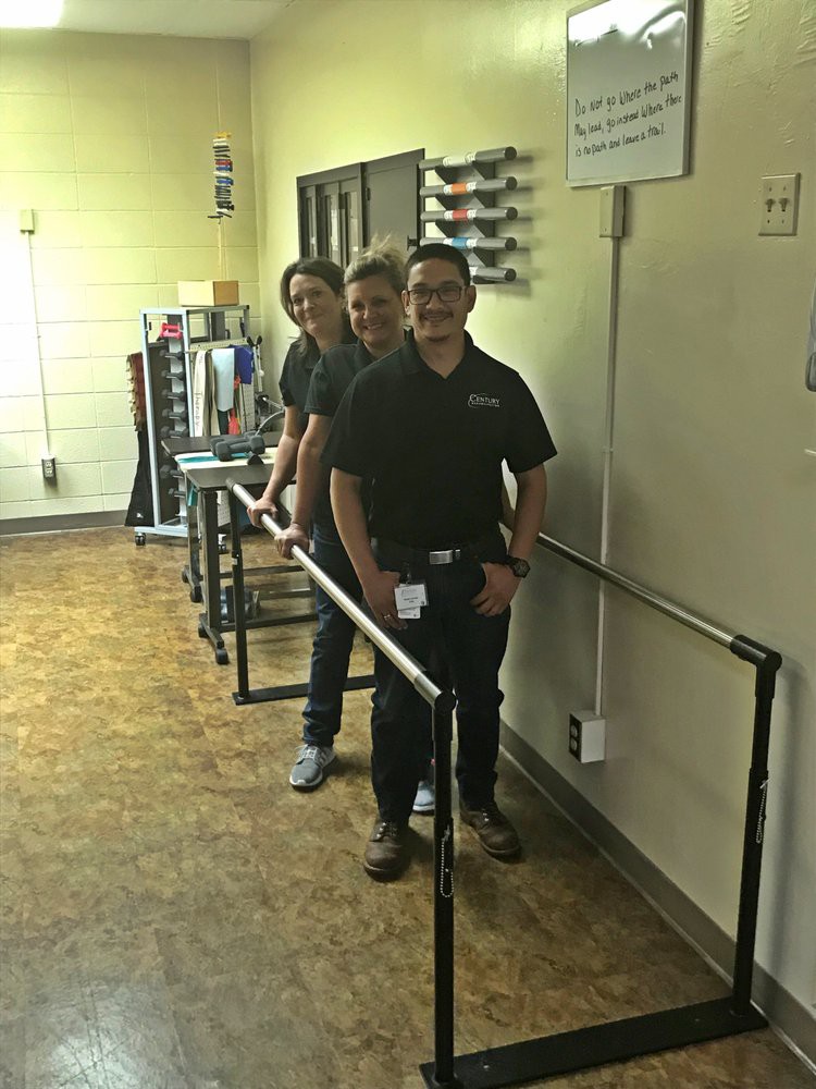 Three people creating an optical illusion in a hallway.