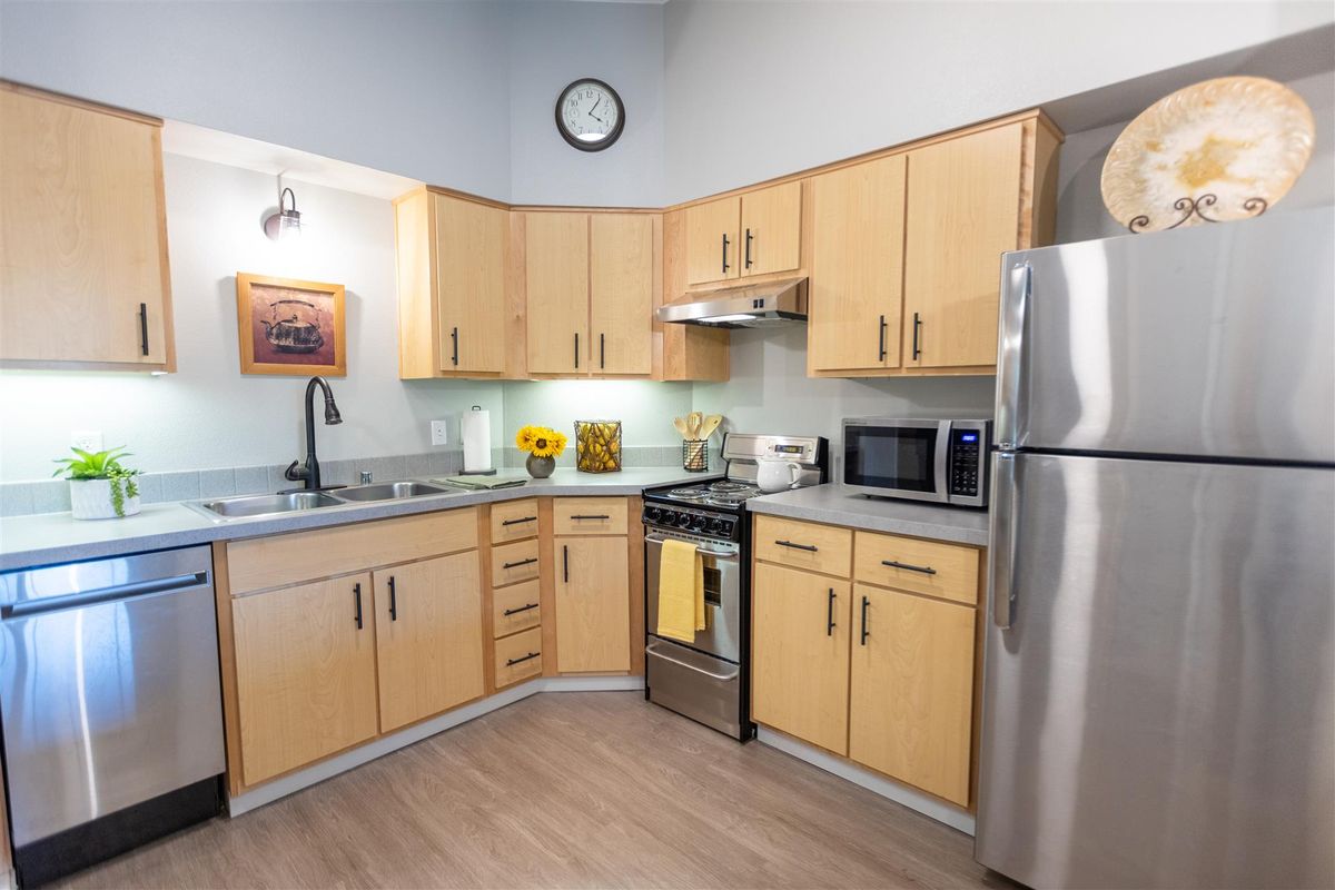 A modern kitchen with wooden cabinets and stainless steel appliances.
