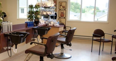 A well-lit hair salon interior featuring styling chairs and a mirror.