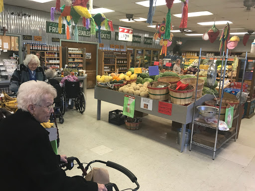 Elderly individuals shopping for fresh produce in a grocery store.