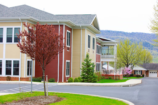 A modern residential building surrounded by lush greenery and trees.