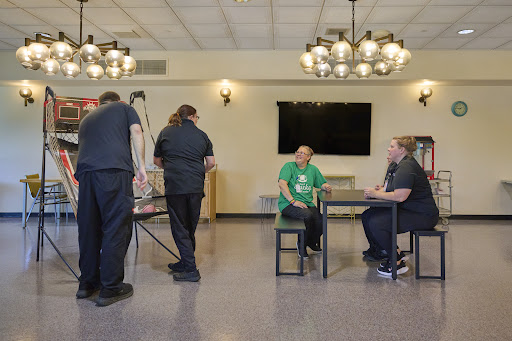 A group of people engaged in an activity in a community room setting.