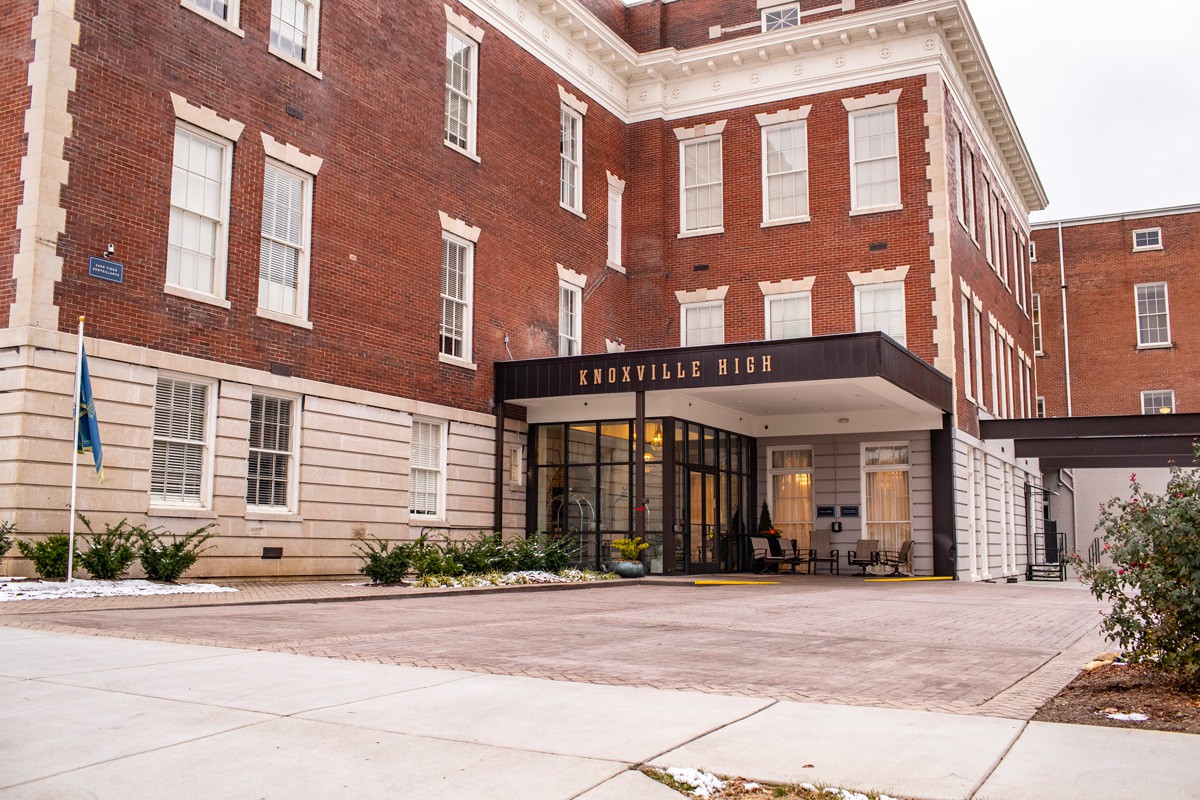 The entrance of a hotel building with classic architecture and a welcoming awning.