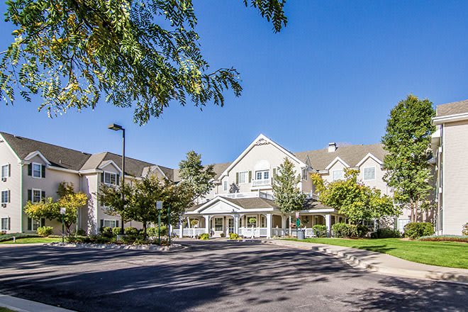 A sunny day view of a residential building surrounded by trees.