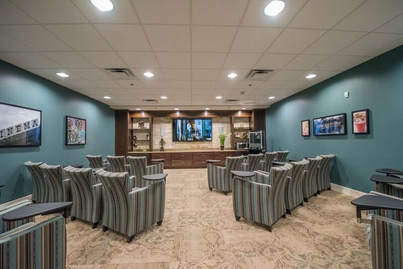 A modern conference room with arranged seating and a large television.