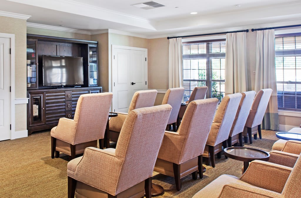 A cozy conference room with comfortable chairs facing a television, ready for a meeting.